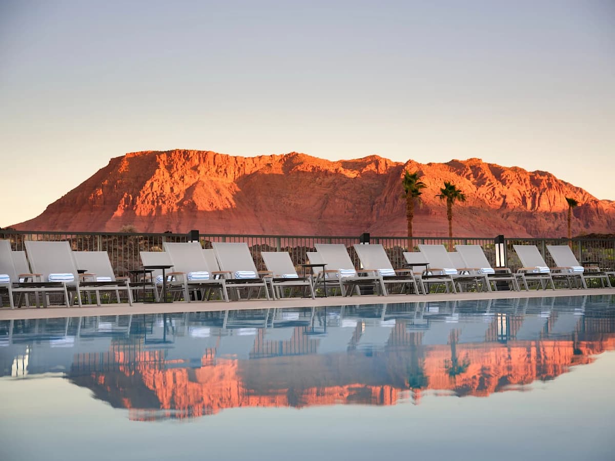 Infinity pool at sunset reflecting the red mesa